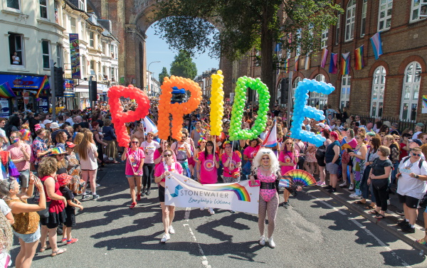 A pride parade with a Stonewater banner